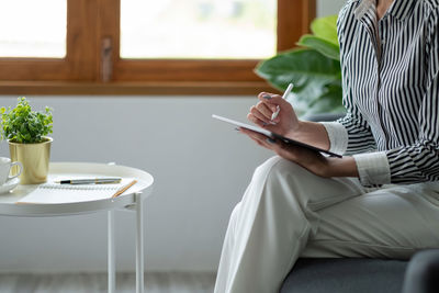 Midsection of woman using mobile phone