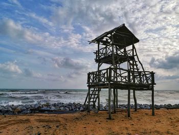 Lifeguard hut on beach against sky