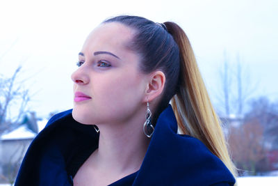 Beautiful young woman looking away in city