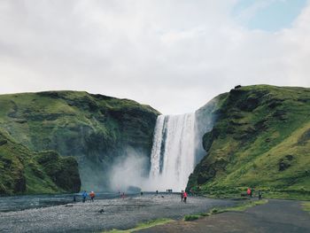 Rear view of man standing against waterfall