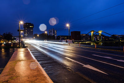 Light trails on road against sky at night