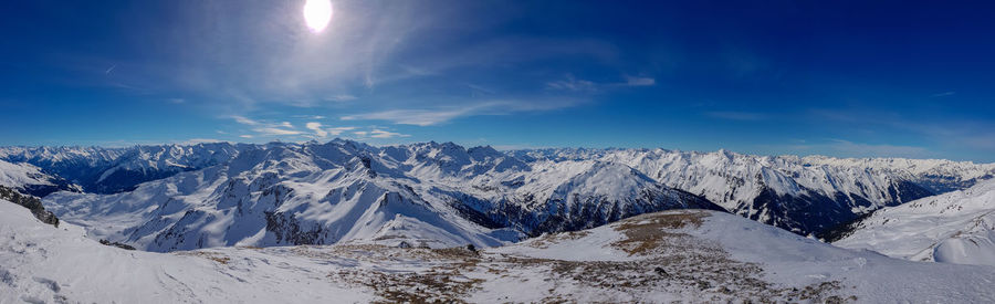 Panoramic view of snowcapped mountains against blue sky