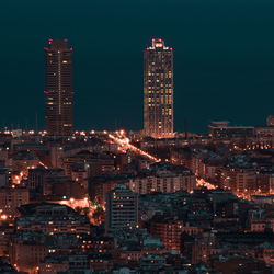 Illuminated cityscape against sky at night