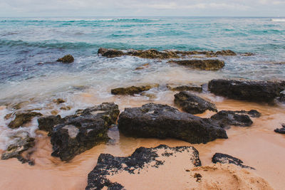 Rocks on beach against sky