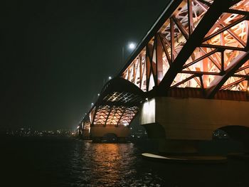 View of bridge over river at night