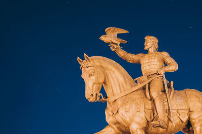 Low angle view of statue against blue sky