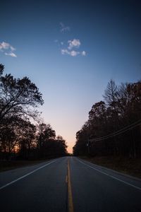 Road amidst trees against sky