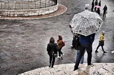 High angle view of people on wet footpath