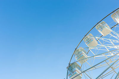 Low angle view of ferris wheel against clear blue sky