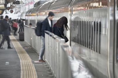 Rear view of woman on train at railroad station platform