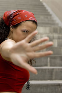 Close-up portrait of woman gesturing while standing by steps outdoors