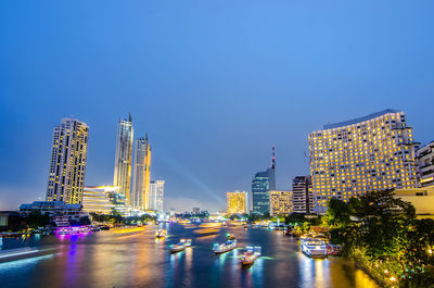 Illuminated buildings in city against sky