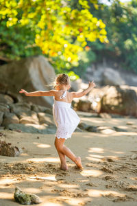 Full length of young woman jumping on road