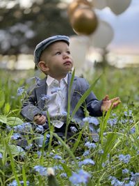 Boy looking at flowering plants on field