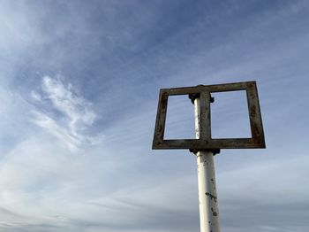 Low angle view of sign against blue sky