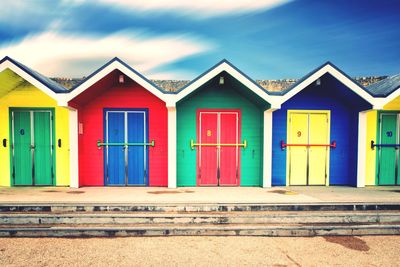 Multi colored houses on beach against sky