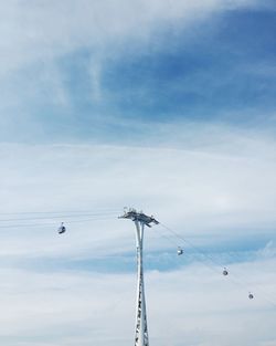 Low angle view of overhead cable car against sky