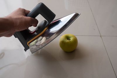 Cropped image of hand holding iron apple