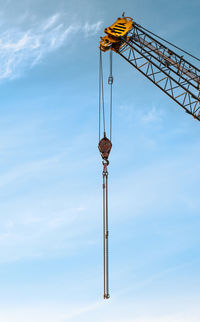 Crane hook with chains on blue sky