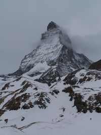 Low angle view of snowcapped mountain against clear sky