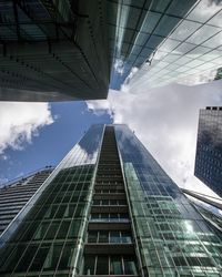 Low angle view of modern buildings against cloudy sky