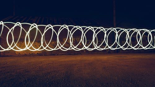 Light trails on field against sky at night