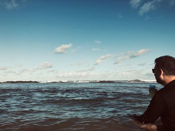 Side view of man on beach against sky