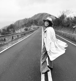 Portrait of young woman walking on road