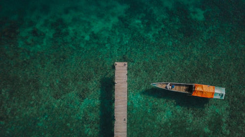 Aerial view of boat moored at pier in sea