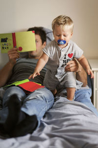 Boy sitting on bed at home