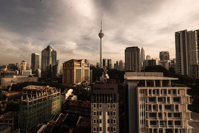 Modern buildings in city against cloudy sky