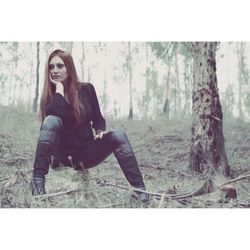 Portrait of young woman sitting on land