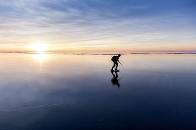 Person long-distance skating at sunset, vanern, sweden