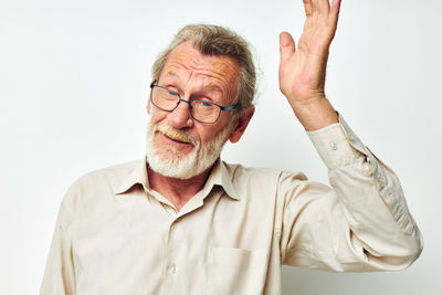 Portrait of young man gesturing against white background