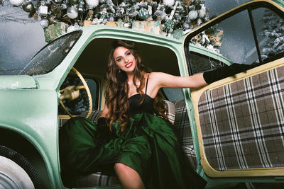 A charming girl is happy about the new year and poses on the ice rink dressing up a christmas tree