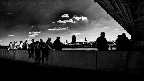 Silhouette of people in city against sky