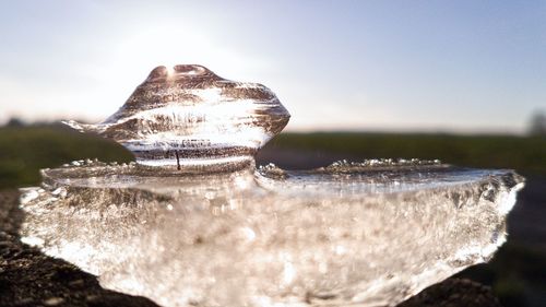 Close-up of rock in water against sky