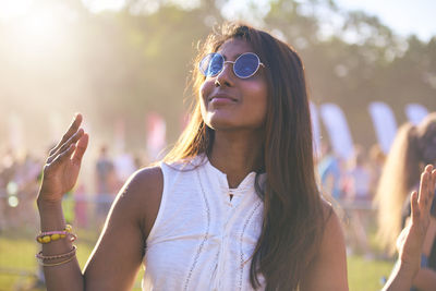 Thoughtful beautiful woman gesturing at carnival