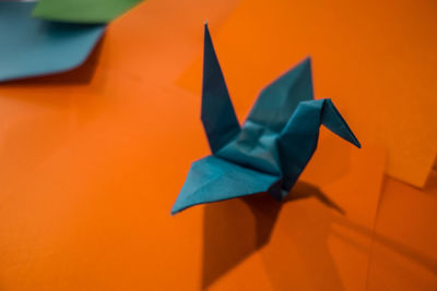 Close-up of paper bird against orange background