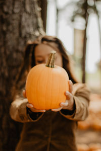 Midsection of man holding pumpkin during halloween