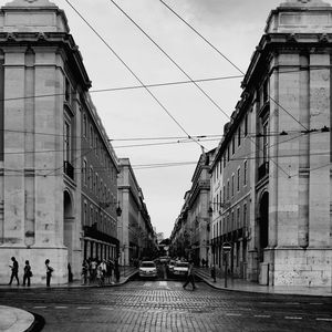 People walking on street amidst buildings in city