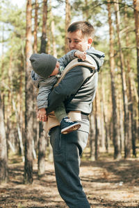 Side view of father with daughter in forest