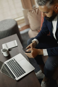 Businessman using cell phone in cafe