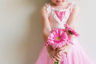 Low angle view of woman holding pink flower