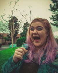 Woman with dyed hair laughing outdoors