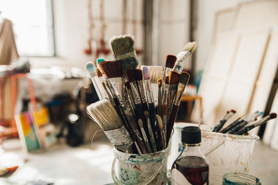 Close-up of paintbrushes in jar on table