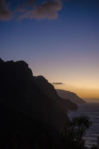 Scenic view of silhouette mountain by sea against sky