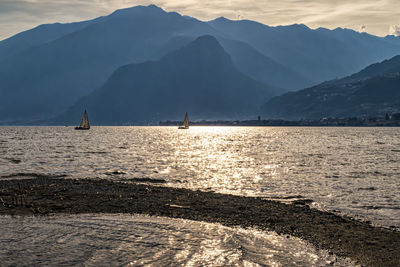 Scenic view of sea and mountains against sky