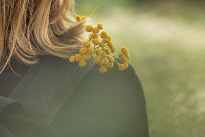 Midsection of woman with yellow flowering plants