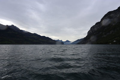 Scenic view of sea and mountains against sky
